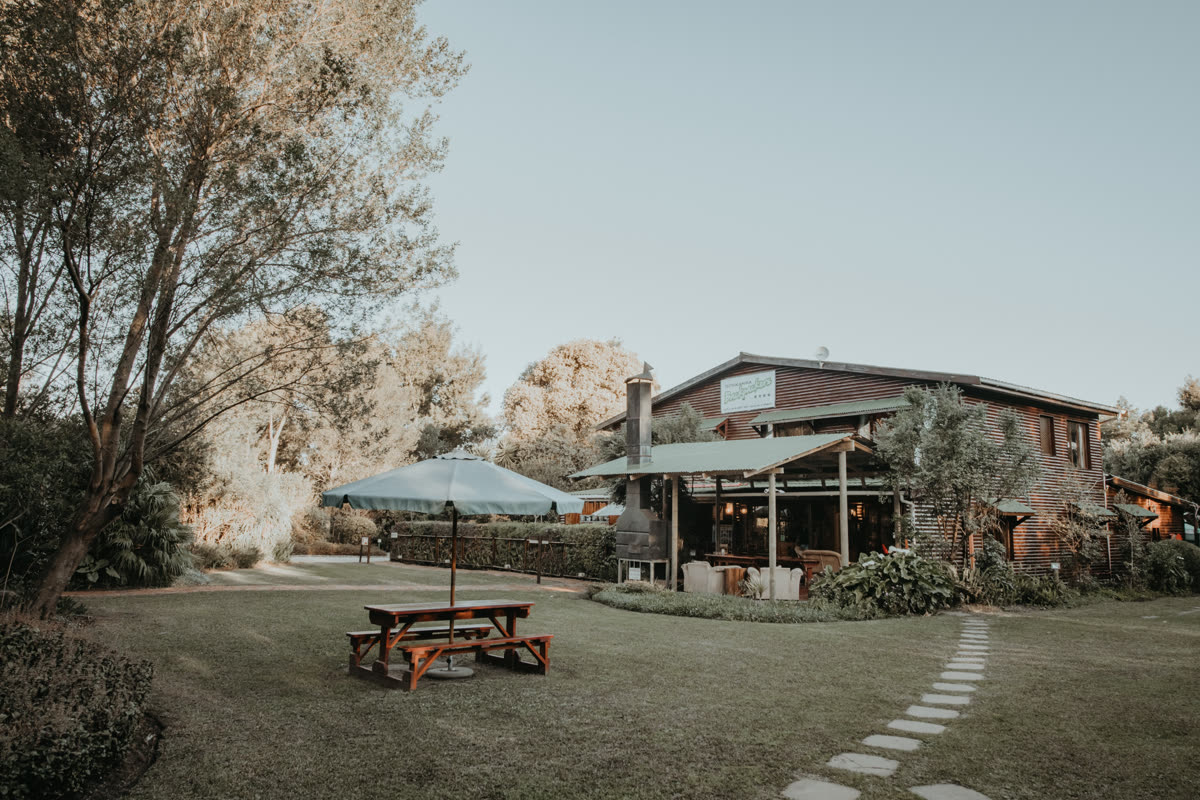 Main lodge building with outdoor dining area and gardens